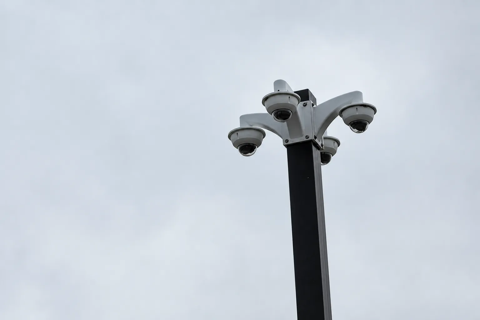 Multi-camera surveillance pole providing broad commercial parking lot coverage
